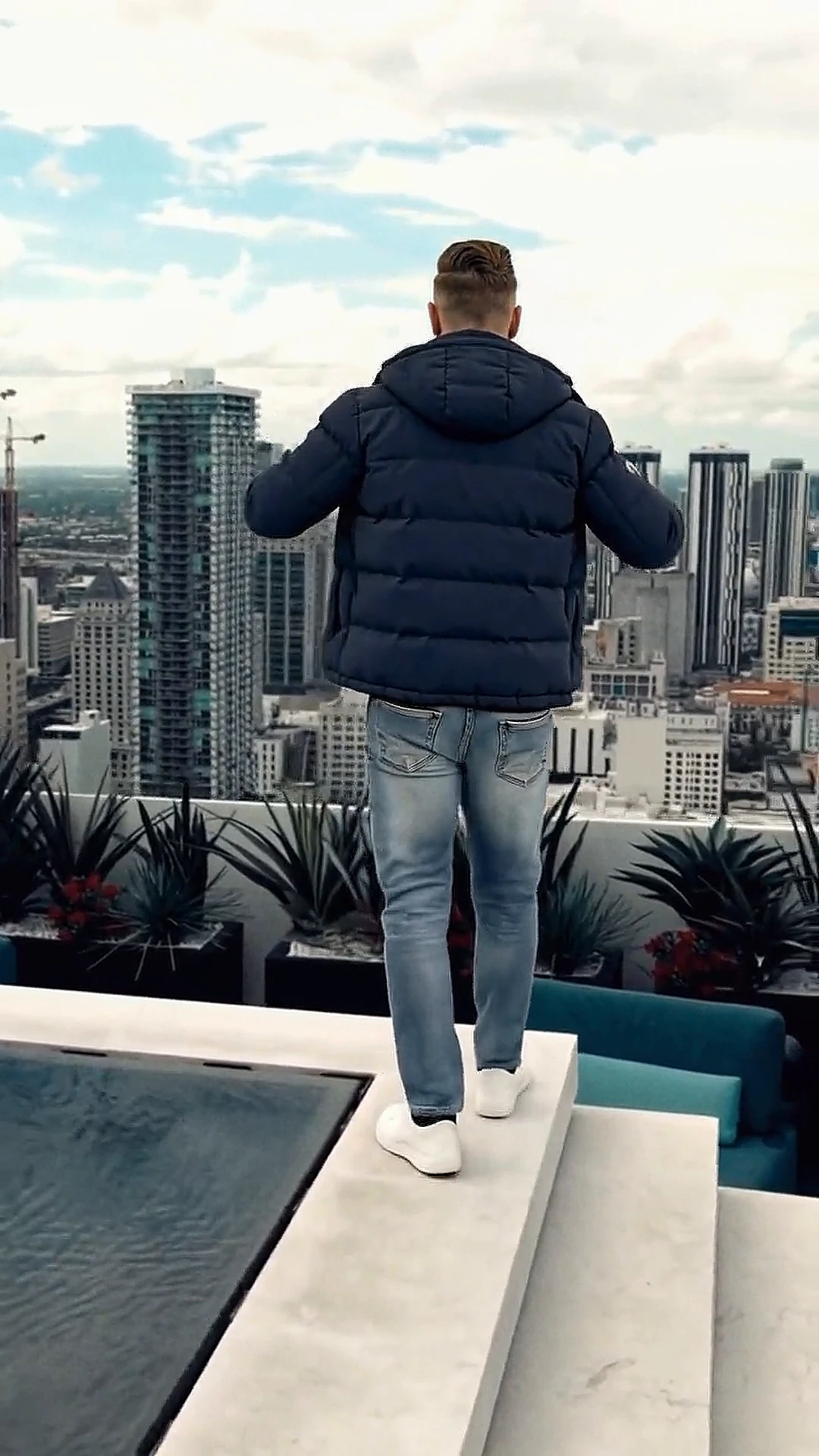 David walking down the steps of a rooftop above the city