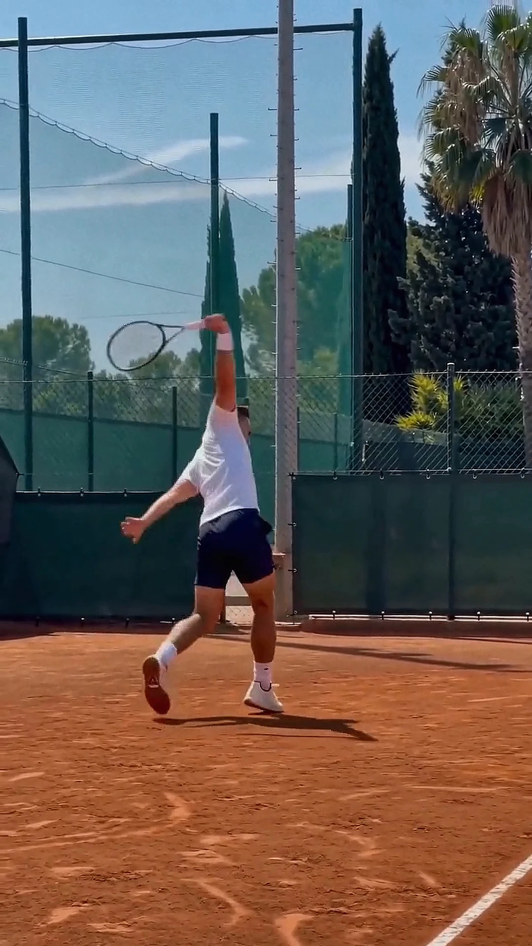 David playing tennis on a clay court